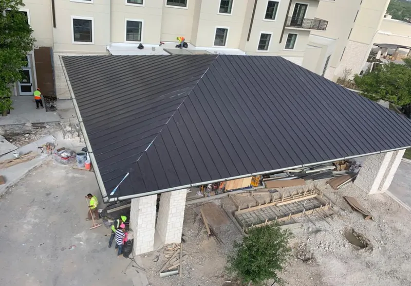 Metal roofing installation team working on a commercial building in Newport